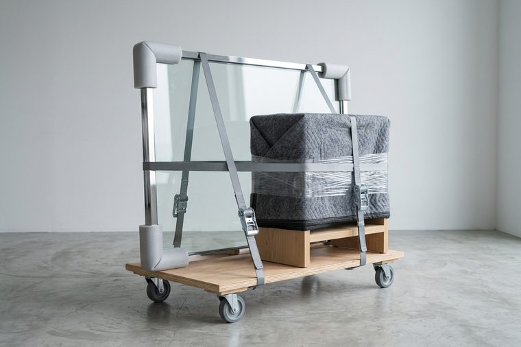 Panneau vitré et mobilier protégés et sanglés sur un plateau roulant